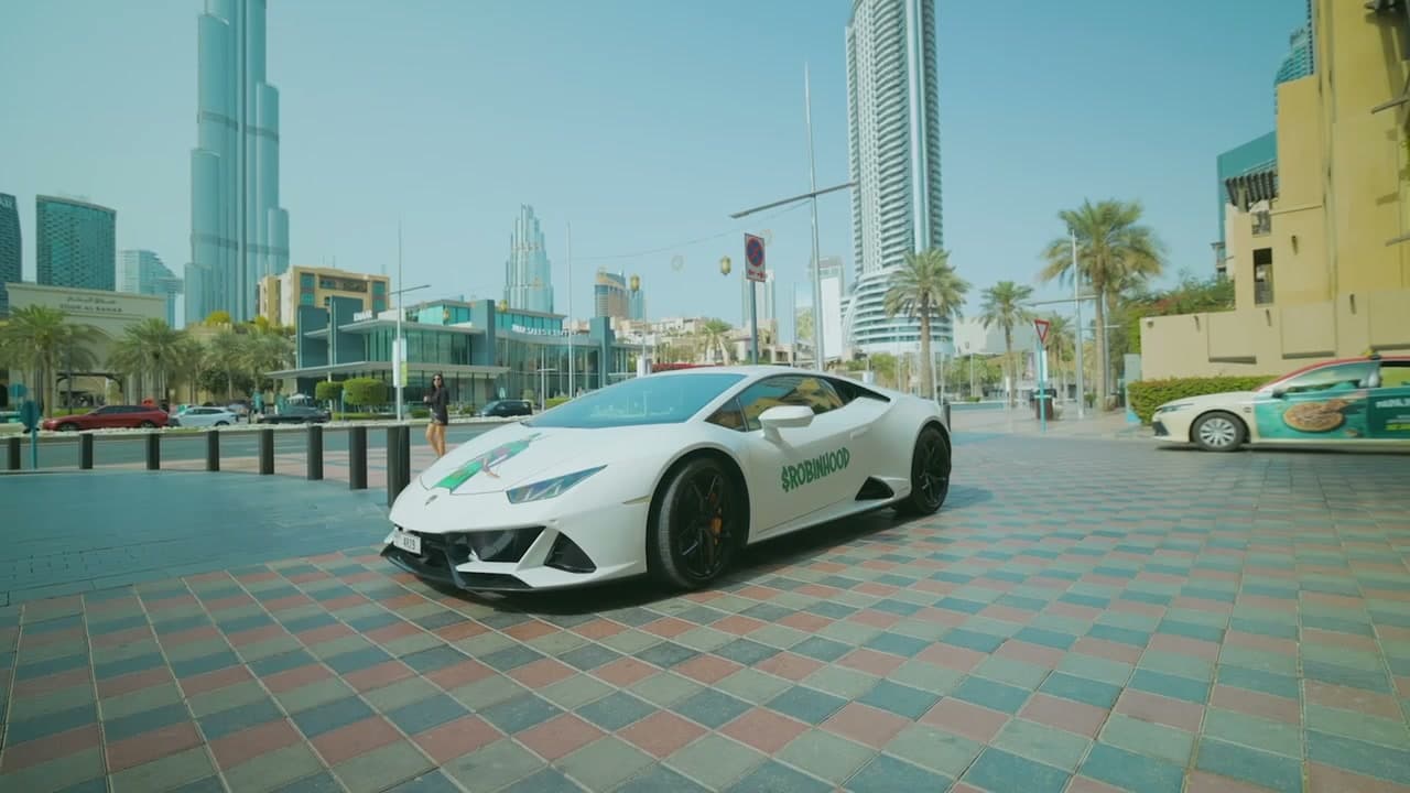 Crypto Lamborghini wrap advertising driving in Dubai past the Burj Khalifa